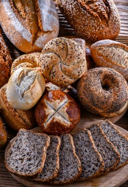Assorted bakery products including loaves of bread and rolls.