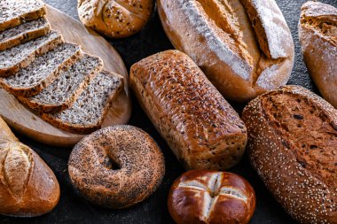 Assorted bakery products including loaves of bread and rolls.