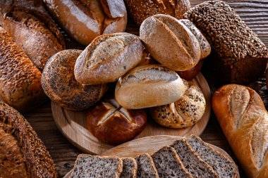 Assorted bakery products including loaves of bread and rolls.