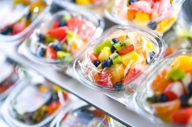 Plastic boxes with pre-packaged fruit salads, put up for sale in a commercial refrigerator