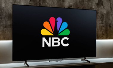 POZNAN, POL - MAR 01, 2024: NBCUniversal 'e ait bir sancak gemisi özelliği olan Amerikan İngilizce ticari radyo ve televizyon ağı NBC' nin logosunu gösteren düz ekran televizyon seti