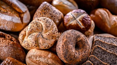 Assorted bakery products including loaves of bread and rolls.