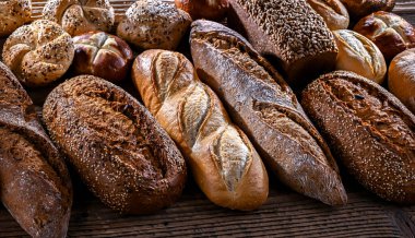 Assorted bakery products including loaves of bread and rolls.