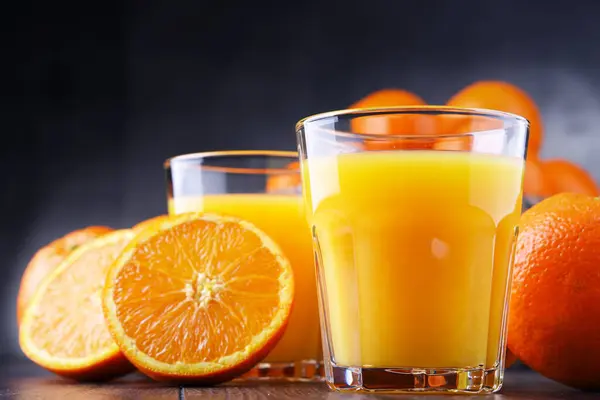Gläser Mit Frisch Gepresstem Orangensaft Und Früchten lizenzfreie Stockbilder