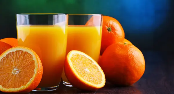 Gläser Mit Frisch Gepresstem Orangensaft Und Früchten Stockbild