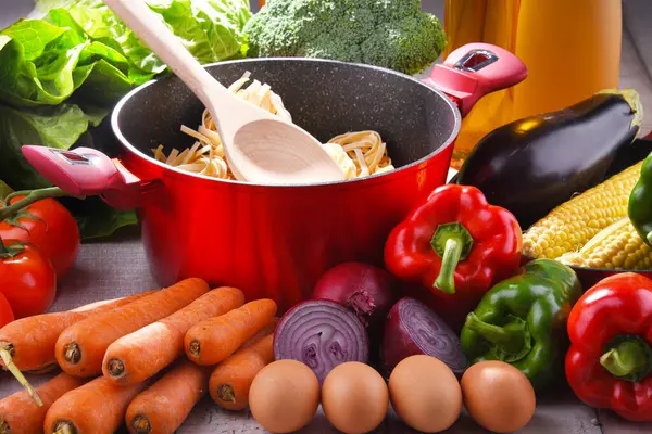 Frisches Gemüse Und Kochtopf Auf Küchentisch lizenzfreie Stockfotos