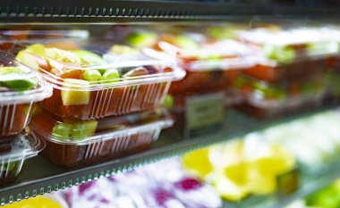 Ticari bir buzdolabında taze meyve sergilenen plastik kutular. Meyve salatası.