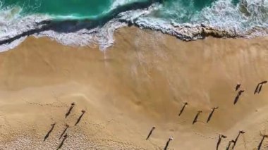 Endonezya 'daki Nusa Penida Adası' ndaki Kelingking Sahili 'nde insanlar ve deniz dalgaları