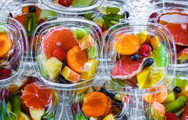 Plastic boxes with pre-packaged fruit salads, put up for sale in a commercial refrigerator