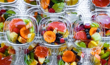 Plastic boxes with pre-packaged fruit salads, put up for sale in a commercial refrigerator