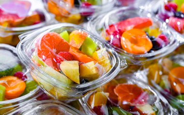 Plastic boxes with pre-packaged fruit salads, put up for sale in a commercial refrigerator