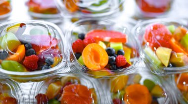 Plastic boxes with pre-packaged fruit salads, put up for sale in a commercial refrigerator