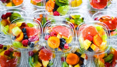 Plastic boxes with pre-packaged fruit salads, put up for sale in a commercial refrigerator