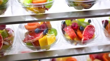 Plastic boxes with pre-packaged fruit salads, put up for sale in a commercial refrigerator