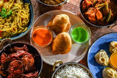 Hint yemekleri ile kompozisyon: samosa, pakora, palak paneer, jalfrezi, thukpa ve naan ekmeği