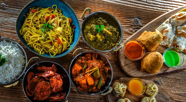 Stock image Composition with indian dishes: samosa, pakora, palak paneer, jalfrezi, thukpa and naan bread