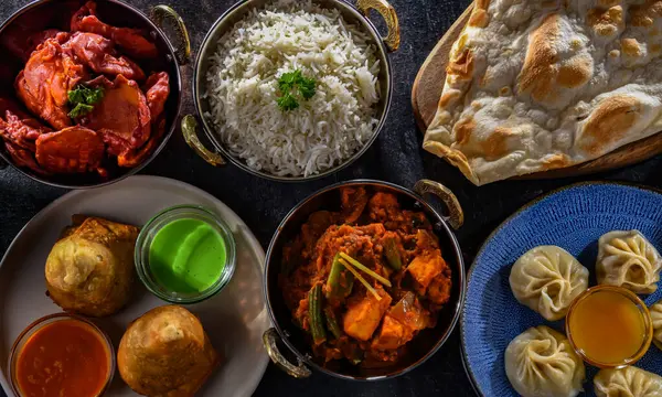 Stock image Composition with indian dishes: samosa, pakora, palak paneer, jalfrezi, thukpa and naan bread