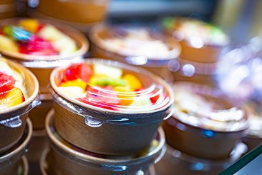 Önceden paketlenmiş meyve salataları ticari bir buzdolabında sergileniyor.