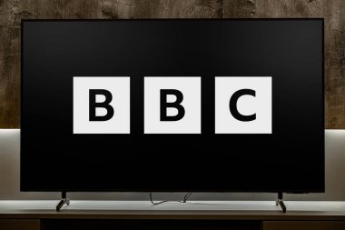 POZNAN, POL - 31 Temmuz 2024: Merkezi Londra 'da bulunan bir İngiliz kamu yayın kuruluşu olan BBC' nin logosunu gösteren düz ekran televizyon