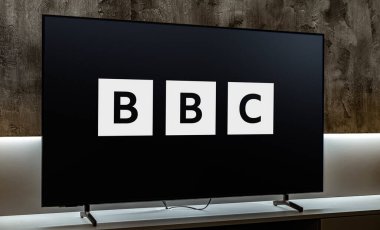 POZNAN, POL - 31 Temmuz 2024: Merkezi Londra 'da bulunan bir İngiliz kamu yayın kuruluşu olan BBC' nin logosunu gösteren düz ekran televizyon