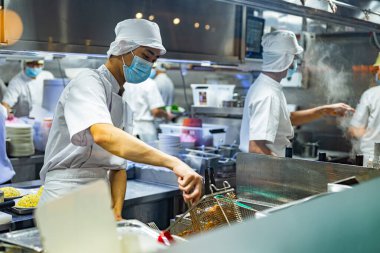 SINGAPORE - 11 Mayıs 2024: Singapur 'daki bir alışveriş merkezinde çalışırken mutfak personeli