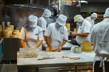 SINGAPORE - 11 Mayıs 2024: Singapur 'daki bir alışveriş merkezinde çalışırken mutfak personeli