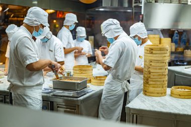 SINGAPORE - 11 Mayıs 2024: Singapur 'daki bir alışveriş merkezinde çalışırken mutfak personeli