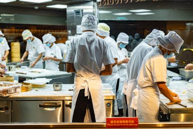 SINGAPORE - 11 Mayıs 2024: Singapur 'daki bir alışveriş merkezinde çalışırken mutfak personeli