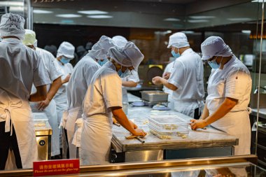 SINGAPORE - 11 Mayıs 2024: Singapur 'daki bir alışveriş merkezinde çalışırken mutfak personeli