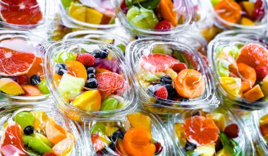 Plastic boxes with pre-packaged fruit salads, put up for sale in a commercial refrigerator