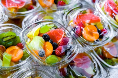 Plastic boxes with pre-packaged fruit salads, put up for sale in a commercial refrigerator