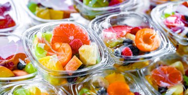 Plastic boxes with pre-packaged fruit salads, put up for sale in a commercial refrigerator