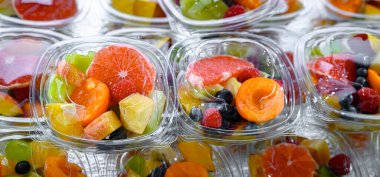 Plastic boxes with pre-packaged fruit salads, put up for sale in a commercial refrigerator