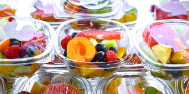 Plastic boxes with pre-packaged fruit salads, put up for sale in a commercial refrigerator