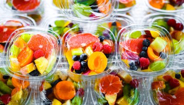 Plastic boxes with pre-packaged fruit salads, put up for sale in a commercial refrigerator