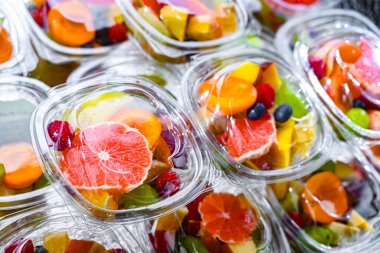 Plastic boxes with pre-packaged fruit salads, put up for sale in a commercial refrigerator