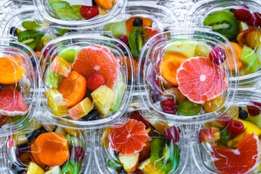 Plastic boxes with pre-packaged fruit salads, put up for sale in a commercial refrigerator