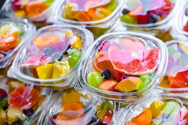 Plastic boxes with pre-packaged fruit salads, put up for sale in a commercial refrigerator