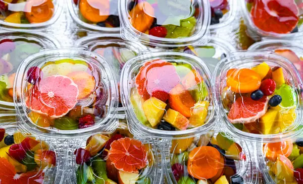 Plastic boxes with pre-packaged fruit salads, put up for sale in a commercial refrigerator