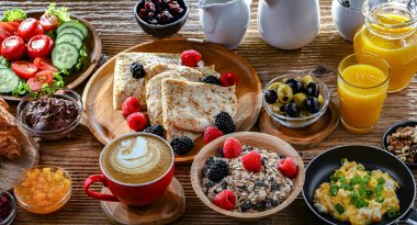 Kahvaltının yanında kahve, portakal suyu, kruvasan, mısır gevreği, çırpılmış yumurta ve krep var..