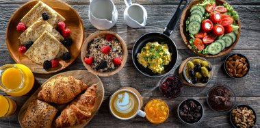 Kahvaltının yanında kahve, portakal suyu, kruvasan, mısır gevreği, çırpılmış yumurta ve krep var..