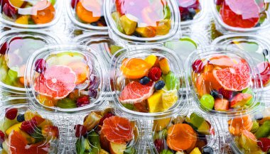 Plastic boxes with pre-packaged fruit salads, put up for sale in a commercial refrigerator