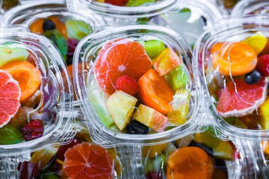 Plastic boxes with pre-packaged fruit salads, put up for sale in a commercial refrigerator