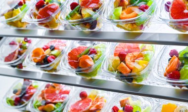 Plastic boxes with pre-packaged fruit salads, put up for sale in a commercial refrigerator