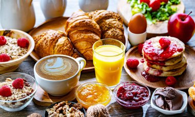 Kahvaltının yanında kahve, portakal suyu, krep, kruvasan, mısır gevreği ve yumurta var..