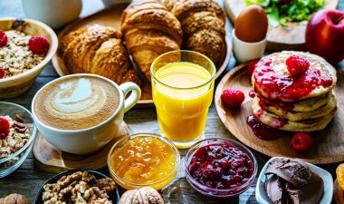 Kahvaltının yanında kahve, portakal suyu, krep, kruvasan, mısır gevreği ve yumurta var..