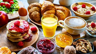 Kahvaltının yanında kahve, portakal suyu, krep, kruvasan, mısır gevreği ve yumurta var..