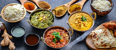 Hint yemekleri ile kompozisyon: medras paneer, palak paneer ve shahi paneer ile orijinal Hint karahi kaplarında servis edilen basmati pilavı