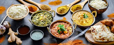 Hint yemekleri ile kompozisyon: medras paneer, palak paneer ve shahi paneer ile orijinal Hint karahi kaplarında servis edilen basmati pilavı