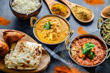 Hint yemekleri ile kompozisyon: medras paneer, palak paneer ve shahi paneer ile orijinal Hint karahi kaplarında servis edilen basmati pilavı